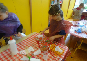 Dziewczynka przygotowuje elementy dekoracyjne do stroju ekologicznego.